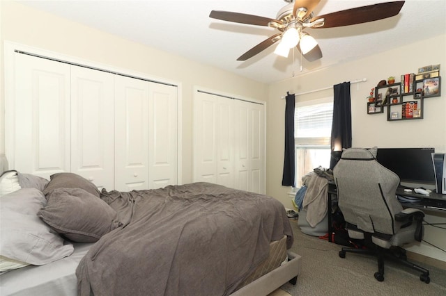 bedroom with two closets, ceiling fan, and carpet floors