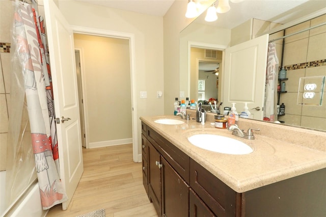 bathroom featuring vanity, ceiling fan, shower / tub combo, and wood-type flooring