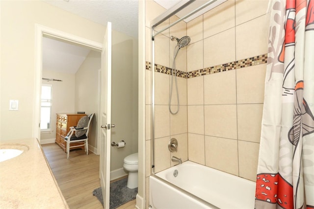 full bathroom featuring toilet, vanity, a textured ceiling, wood-type flooring, and shower / tub combo with curtain