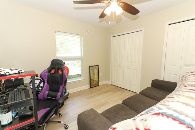 office space with light wood-type flooring and ceiling fan