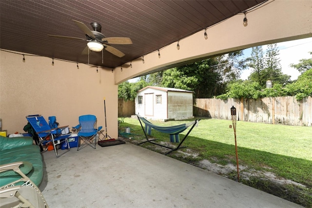 view of patio with ceiling fan and a storage shed