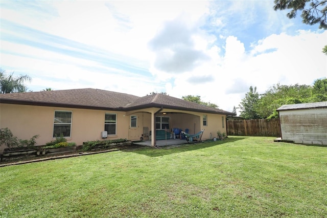 rear view of house featuring a yard and a patio area