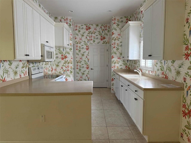 kitchen featuring white cabinetry, white appliances, kitchen peninsula, sink, and light tile patterned flooring