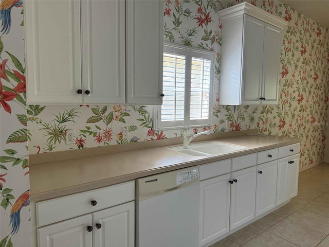 kitchen featuring dishwasher, light tile patterned flooring, sink, and white cabinets