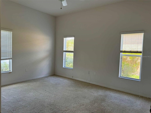 spare room featuring light colored carpet and ceiling fan