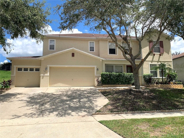 traditional-style home featuring stucco siding, driveway, and a garage