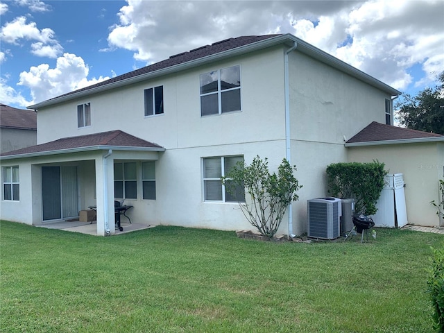 back of property with a lawn, a patio area, and central air condition unit