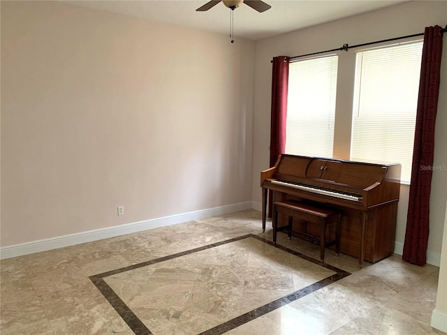 living area with a ceiling fan, baseboards, and marble finish floor