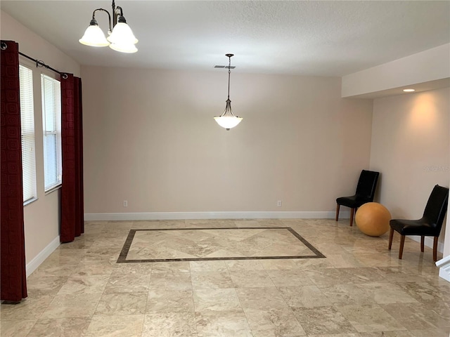 interior space featuring visible vents, baseboards, and a chandelier