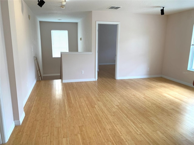 empty room with visible vents, baseboards, and light wood-style floors