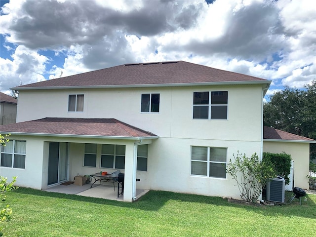 rear view of property with stucco siding, a yard, central AC unit, and a patio area