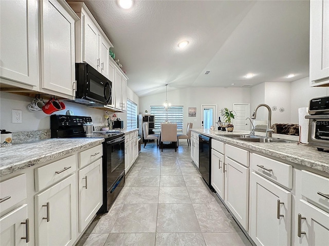 kitchen with light stone countertops, black appliances, sink, white cabinetry, and lofted ceiling