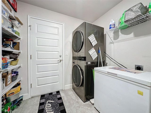 clothes washing area featuring light tile patterned floors and stacked washer / drying machine