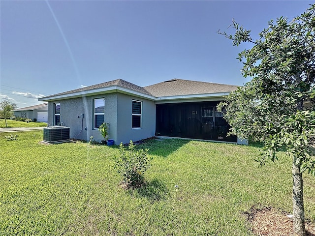 back of property with a lawn and central AC