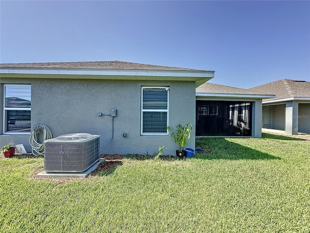 rear view of house with a lawn and central air condition unit