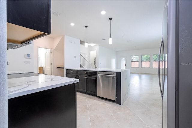 kitchen with light stone countertops, sink, decorative light fixtures, light tile patterned floors, and appliances with stainless steel finishes