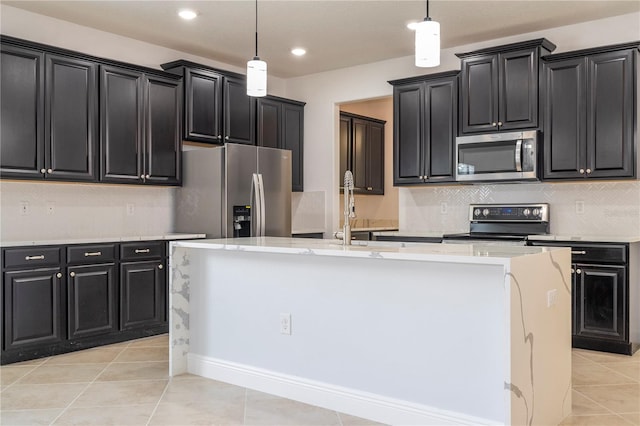 kitchen with pendant lighting, sink, stainless steel appliances, and a center island with sink