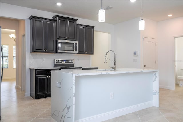 kitchen featuring electric range, a center island with sink, hanging light fixtures, and sink