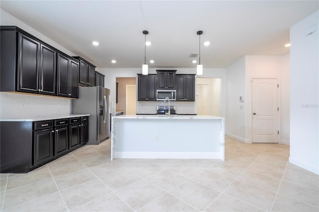 kitchen featuring pendant lighting, light tile patterned flooring, an island with sink, and appliances with stainless steel finishes