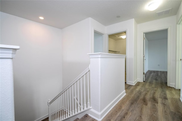 corridor featuring a textured ceiling and dark hardwood / wood-style floors