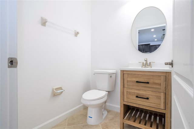 bathroom with toilet, vanity, and tile patterned floors