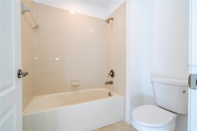 bathroom featuring tile patterned flooring, tiled shower / bath combo, and toilet