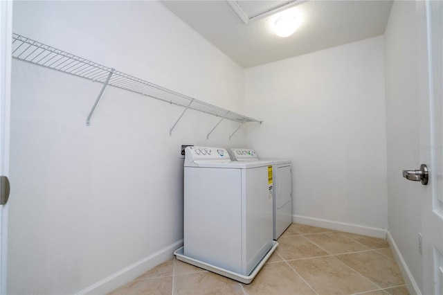 laundry area with separate washer and dryer and light tile patterned flooring