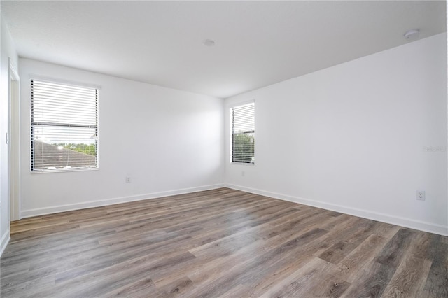 empty room with hardwood / wood-style floors and plenty of natural light