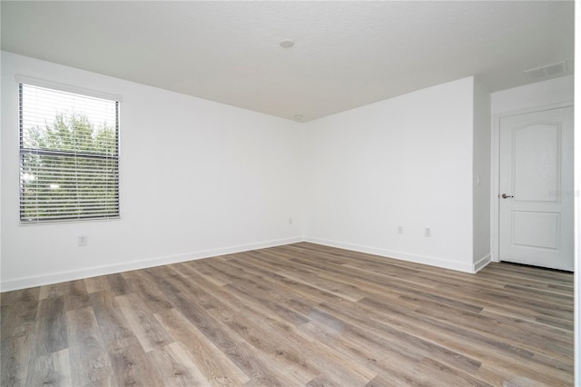 unfurnished room featuring wood-type flooring and a textured ceiling