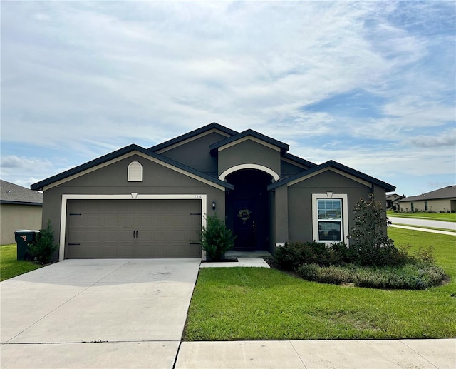 ranch-style house featuring a garage and a front lawn