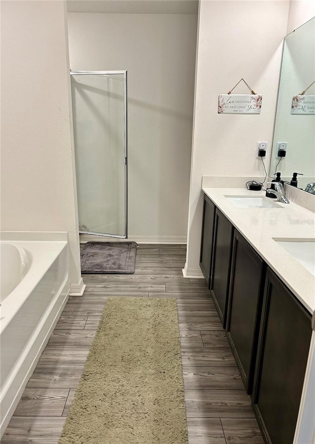 bathroom featuring vanity, wood-type flooring, and shower with separate bathtub