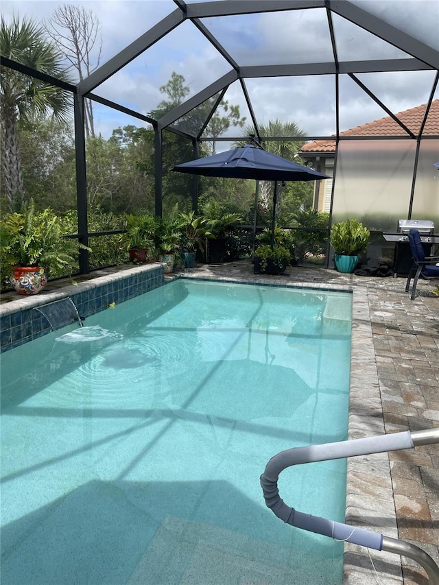 view of swimming pool featuring pool water feature, glass enclosure, and a patio area