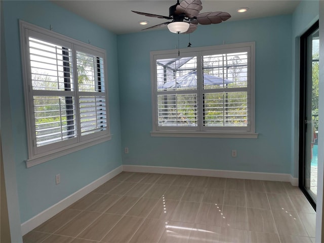 tiled empty room featuring ceiling fan