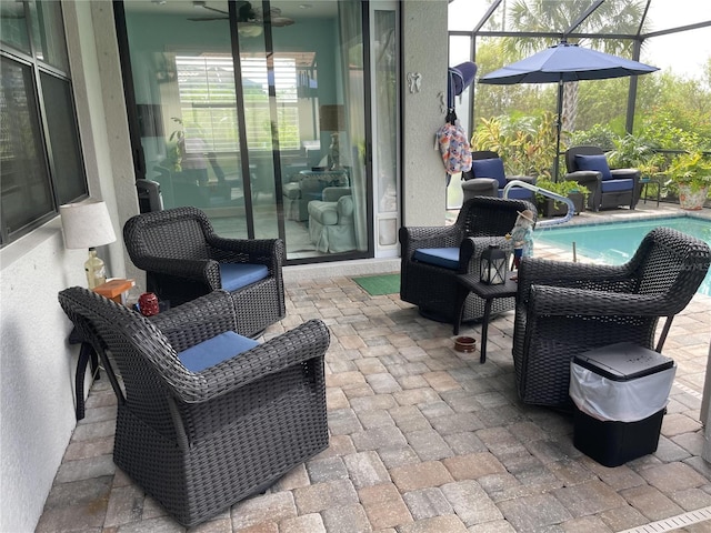 view of patio featuring glass enclosure and ceiling fan