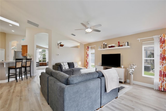 living room featuring a healthy amount of sunlight, ceiling fan, and light hardwood / wood-style flooring