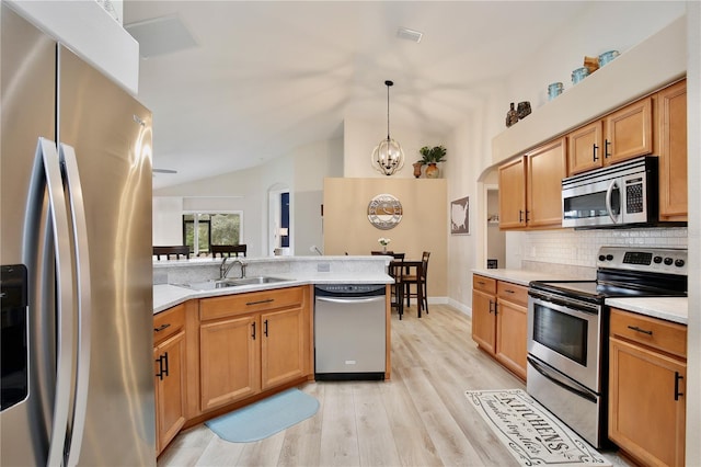 kitchen with sink, vaulted ceiling, light hardwood / wood-style flooring, stainless steel appliances, and decorative light fixtures