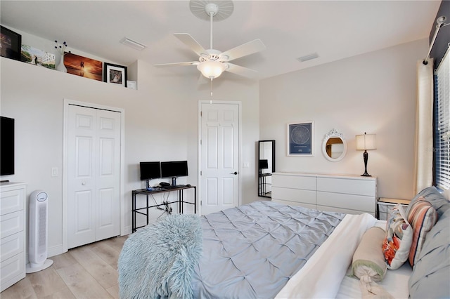 bedroom with light hardwood / wood-style floors, ceiling fan, and a closet