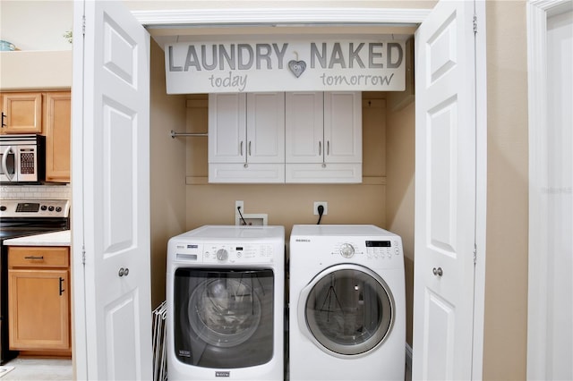 laundry area with independent washer and dryer and cabinets