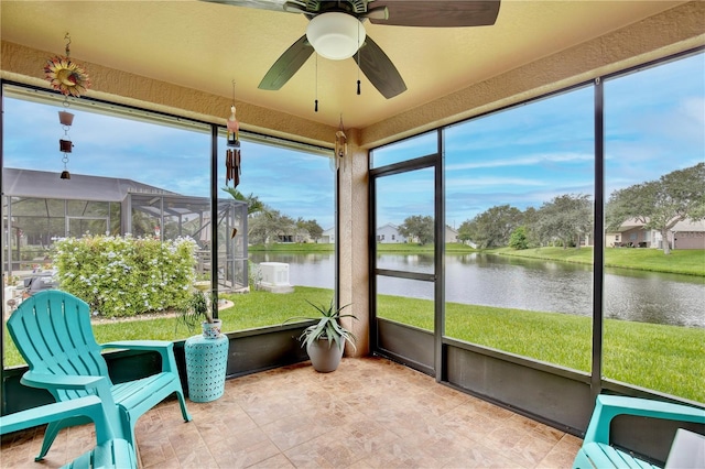 sunroom featuring a water view and ceiling fan