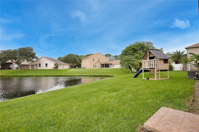 view of yard featuring a playground, cooling unit, and a water view