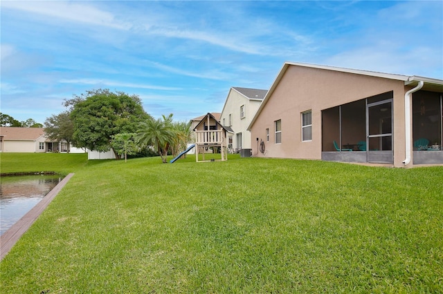 view of yard featuring a sunroom and central air condition unit