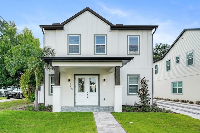 modern farmhouse style home with covered porch and a front yard