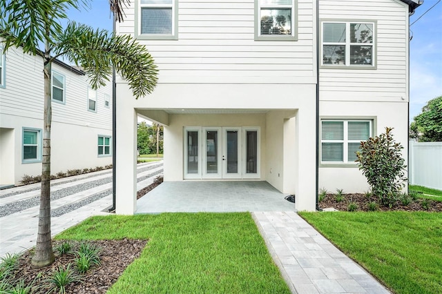 back of property with french doors, a yard, and a patio