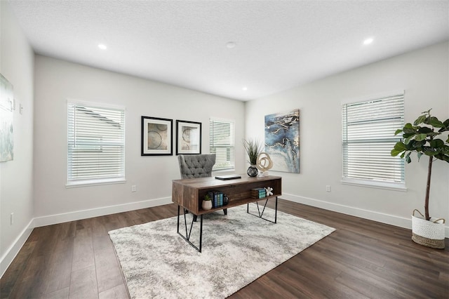 office area with a textured ceiling, dark hardwood / wood-style flooring, and a wealth of natural light