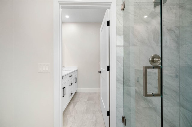 bathroom with a shower with shower door and vanity