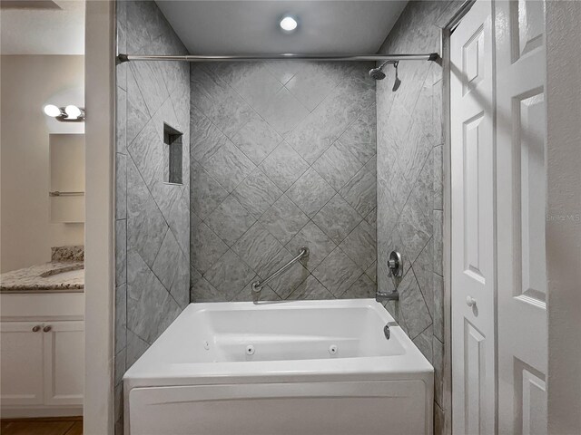 bathroom featuring vanity and tiled shower / bath