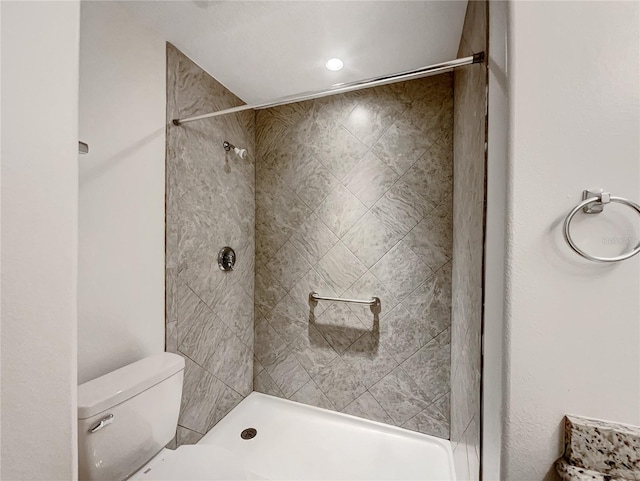 bathroom with toilet and a tile shower