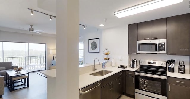 kitchen with dark brown cabinets, kitchen peninsula, sink, ceiling fan, and appliances with stainless steel finishes