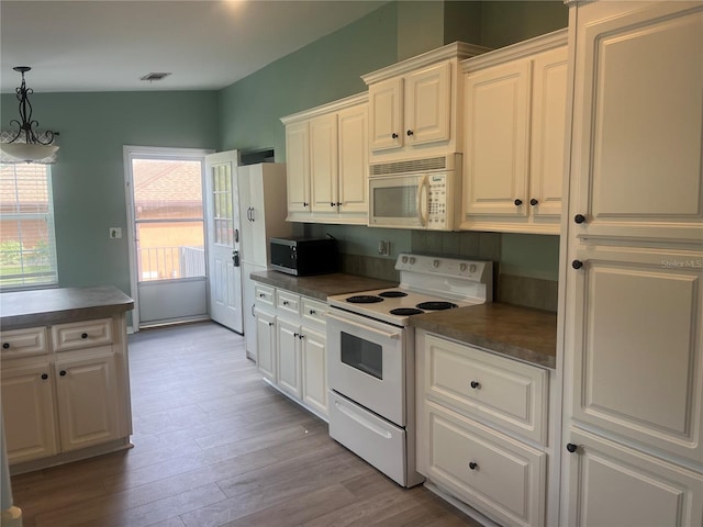 kitchen with white cabinets, hanging light fixtures, a chandelier, light wood-type flooring, and white appliances