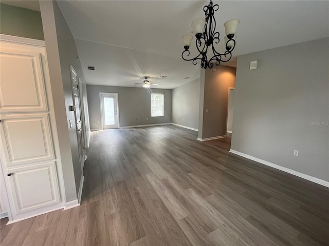 unfurnished dining area featuring ceiling fan with notable chandelier and dark hardwood / wood-style floors